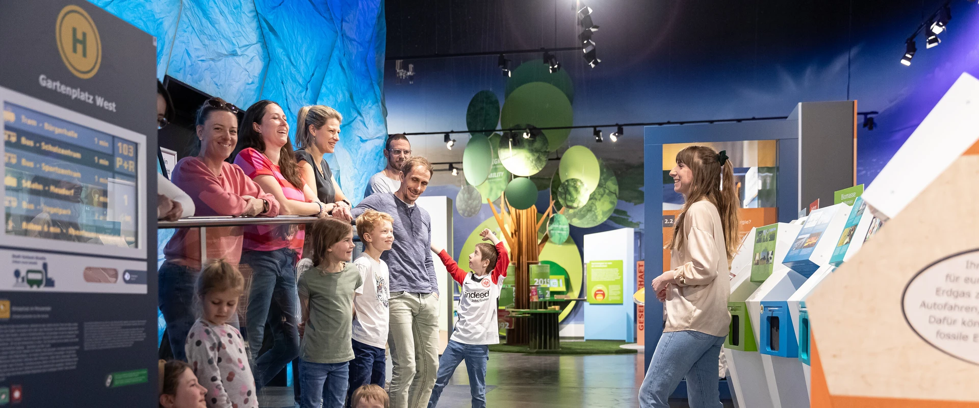 Besucherbetreuerin mit einer Gruppe bei Familienf&uuml;hrung.