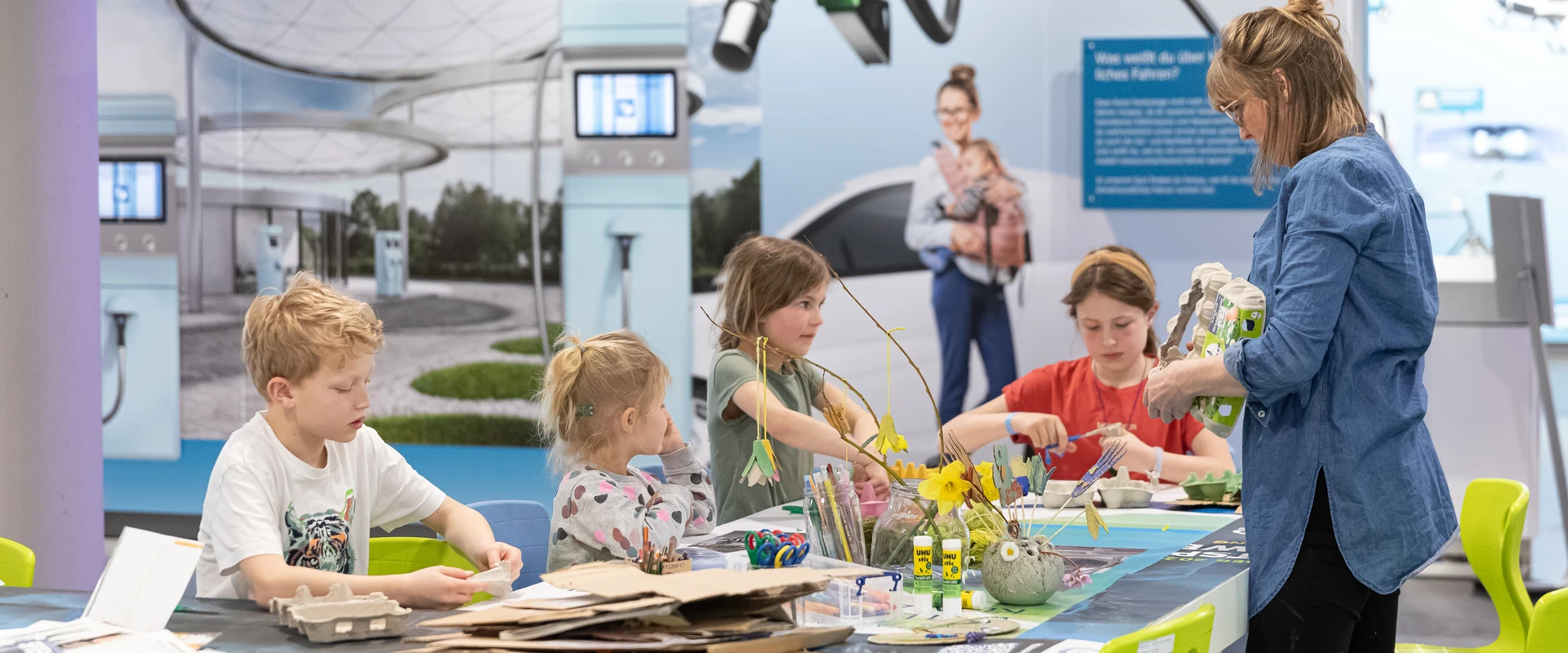 Kinder am Basteltisch in der Ausstellung der KLIMA ARENA.